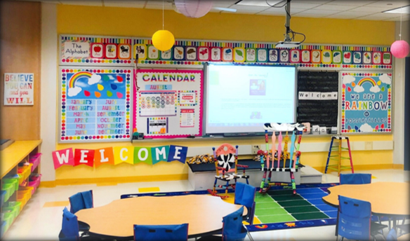A bright, modern 21st-century kindergarten classroom with a smartboard and children seated at roundtables